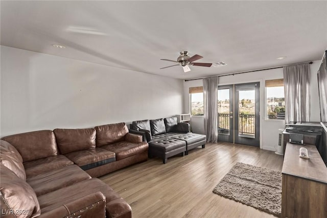 living room featuring light wood-type flooring, ceiling fan, french doors, and visible vents