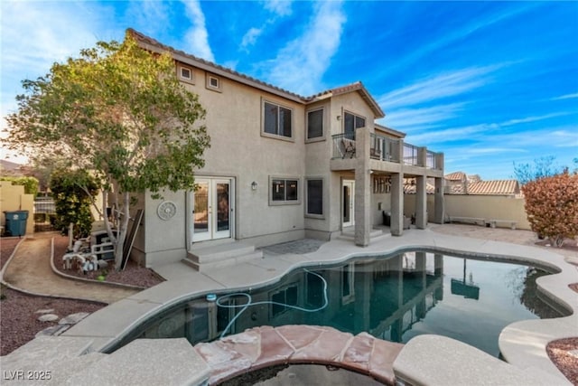 exterior space with a patio, an in ground hot tub, fence, french doors, and a fenced in pool