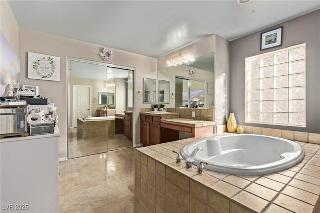 bathroom with a garden tub and vanity