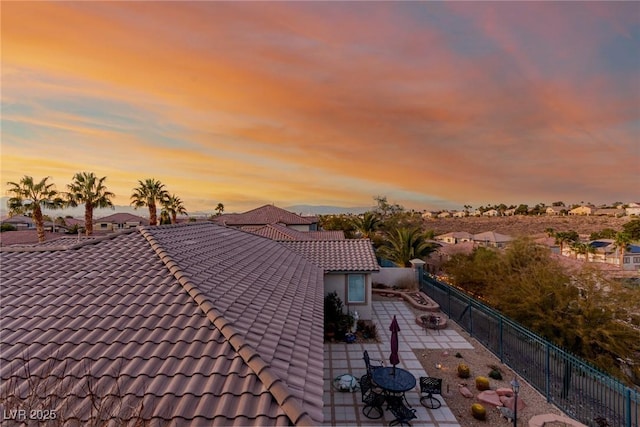 exterior details with a residential view, a tiled roof, and a fenced backyard