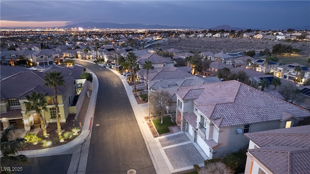 aerial view at dusk featuring a residential view and a mountain view