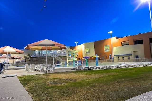 view of home's community featuring a swimming pool, a patio area, and fence