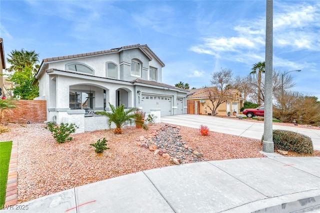 view of front facade featuring a garage, concrete driveway, covered porch, and stucco siding