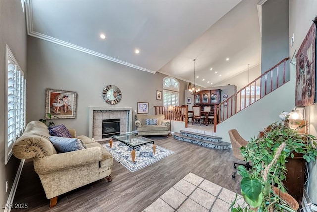 living room with an inviting chandelier, crown molding, stairs, and wood finished floors