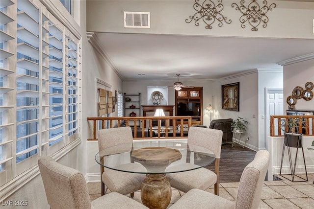 dining area with visible vents, ornamental molding, a ceiling fan, tile patterned flooring, and baseboards