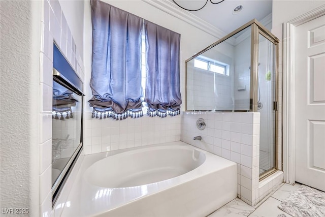 bathroom featuring a bath, marble finish floor, crown molding, and a stall shower