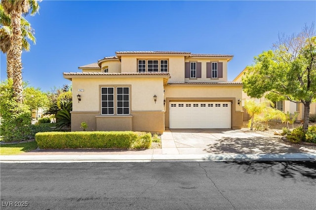 mediterranean / spanish-style house with concrete driveway, an attached garage, a tiled roof, and stucco siding