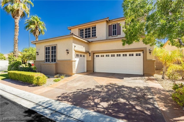 mediterranean / spanish home featuring a garage, driveway, a tiled roof, and stucco siding