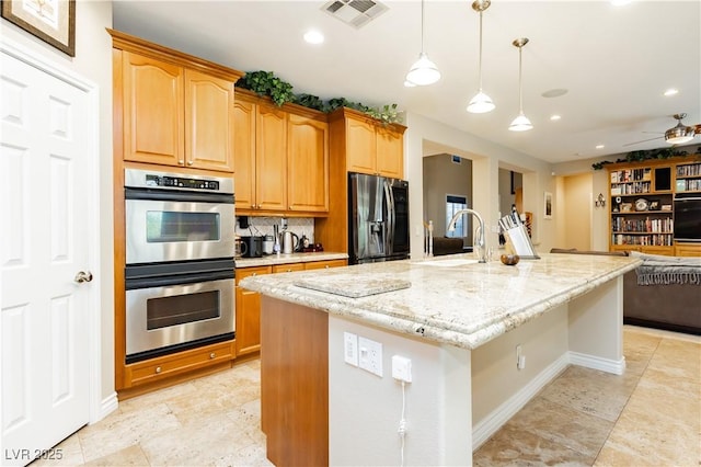 kitchen with visible vents, light stone countertops, fridge with ice dispenser, double oven, and a sink