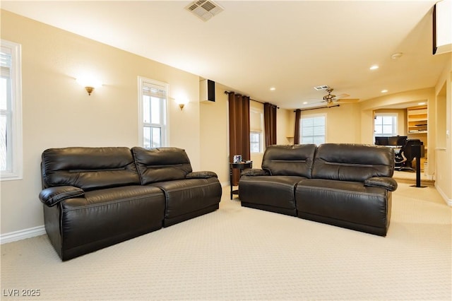 living area with a healthy amount of sunlight, visible vents, light carpet, and baseboards