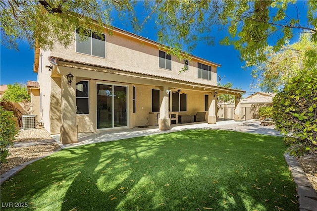 rear view of property featuring a yard, stucco siding, a patio, and fence