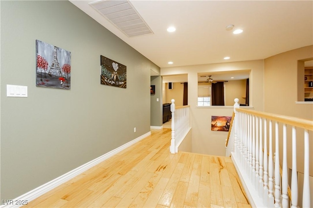 hallway featuring recessed lighting, visible vents, an upstairs landing, baseboards, and hardwood / wood-style flooring