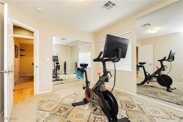 exercise area featuring carpet floors, baseboards, and visible vents