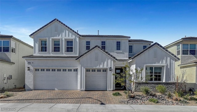 view of front of home featuring decorative driveway, board and batten siding, and an attached garage