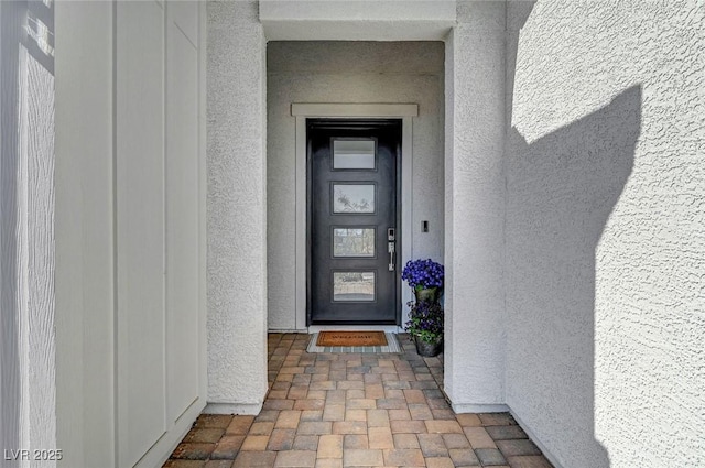 entrance to property featuring stucco siding