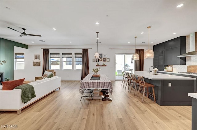 interior space with baseboards, light wood-type flooring, a ceiling fan, and recessed lighting