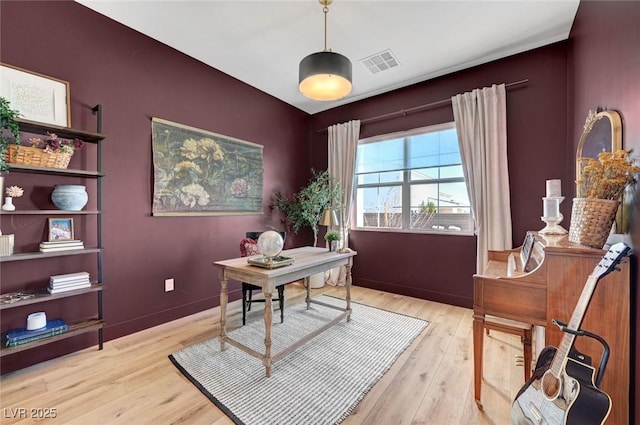 home office featuring visible vents, baseboards, and wood finished floors