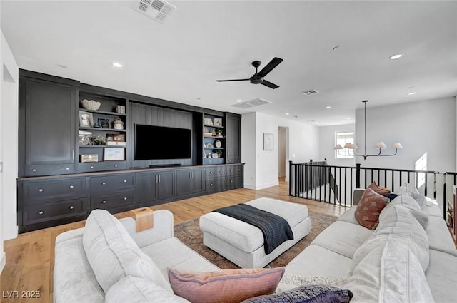 living area featuring light wood-type flooring, visible vents, and recessed lighting