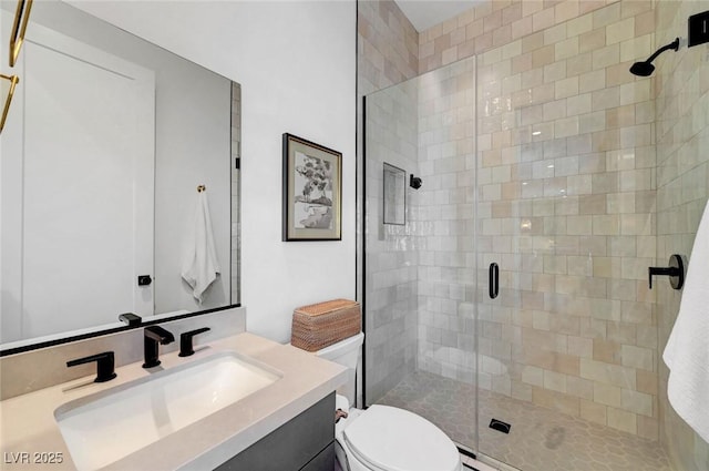 bathroom with a stall shower, vanity, and toilet