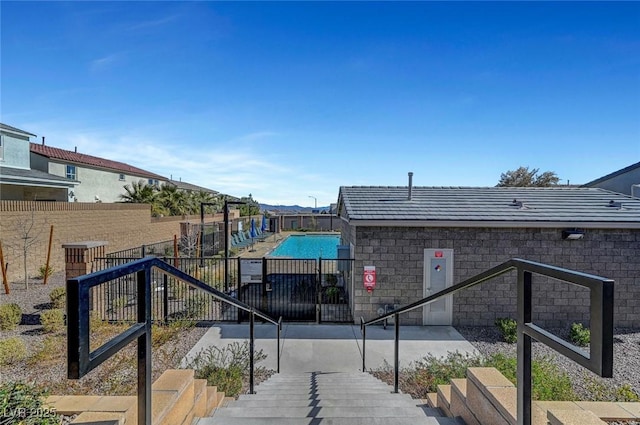 view of home's community featuring a swimming pool and fence