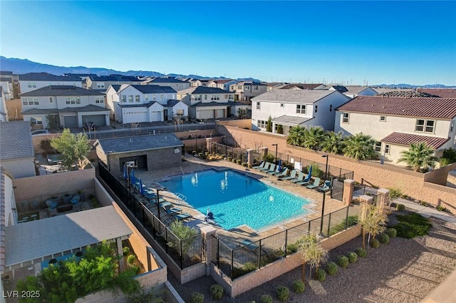 pool featuring a residential view, a patio area, fence, and a mountain view