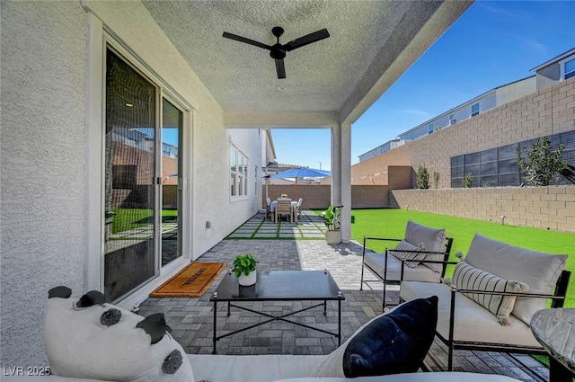 view of patio featuring ceiling fan, outdoor lounge area, and a fenced backyard