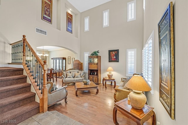 living area featuring a notable chandelier, plenty of natural light, visible vents, and light wood-style floors