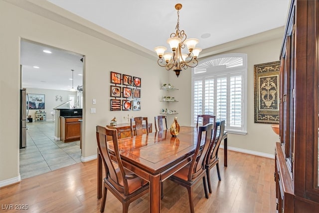 dining room featuring baseboards, recessed lighting, light wood-style flooring, and a notable chandelier