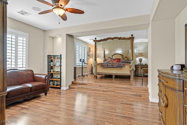 bedroom with light wood-style floors, visible vents, and baseboards