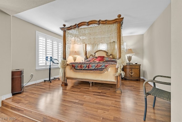 bedroom with baseboards and wood finished floors