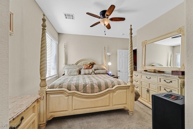 bedroom featuring ceiling fan, visible vents, and light colored carpet