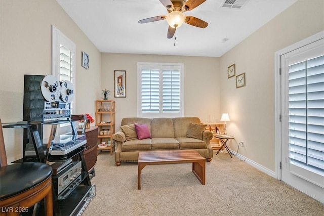 living area featuring a ceiling fan, light colored carpet, visible vents, and baseboards