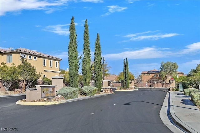 view of road featuring curbs, a gated entry, and a gate