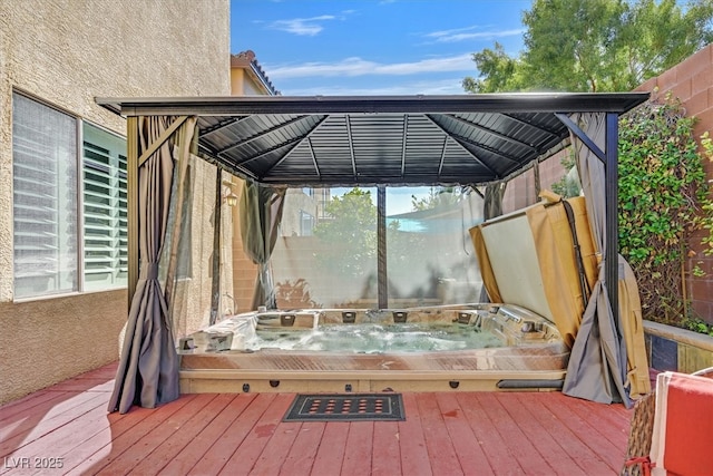 deck featuring a covered hot tub