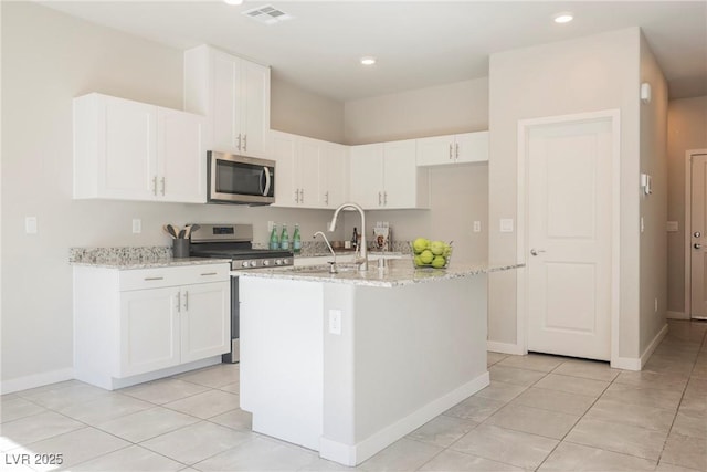 kitchen with appliances with stainless steel finishes, white cabinets, visible vents, and a sink