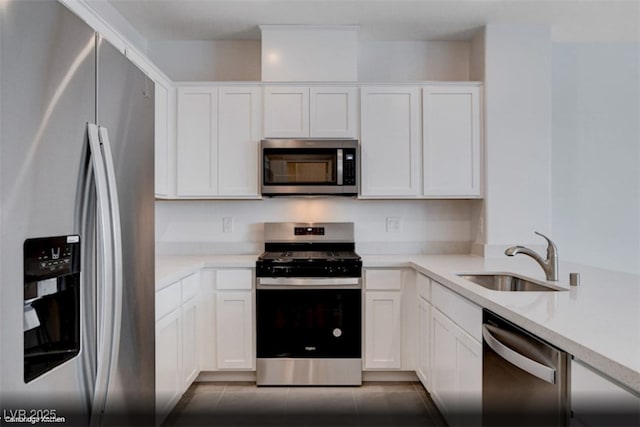 kitchen featuring light countertops, appliances with stainless steel finishes, a sink, and white cabinetry