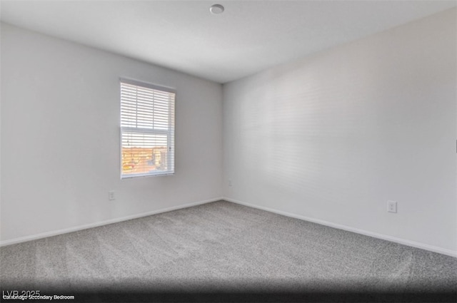 carpeted spare room with baseboards