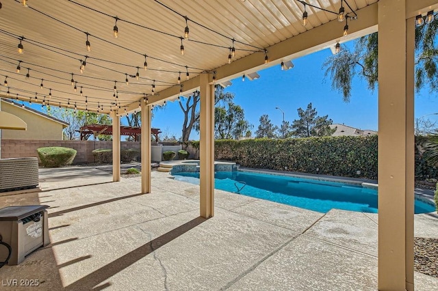 view of swimming pool with a pool with connected hot tub, a fenced backyard, and a patio