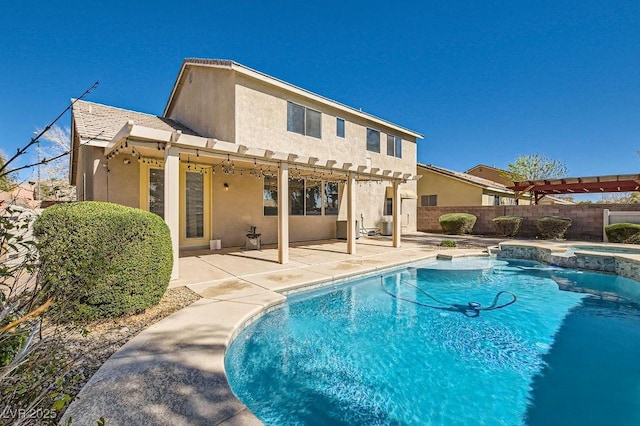 back of house with a patio, fence, a pool with connected hot tub, a pergola, and stucco siding