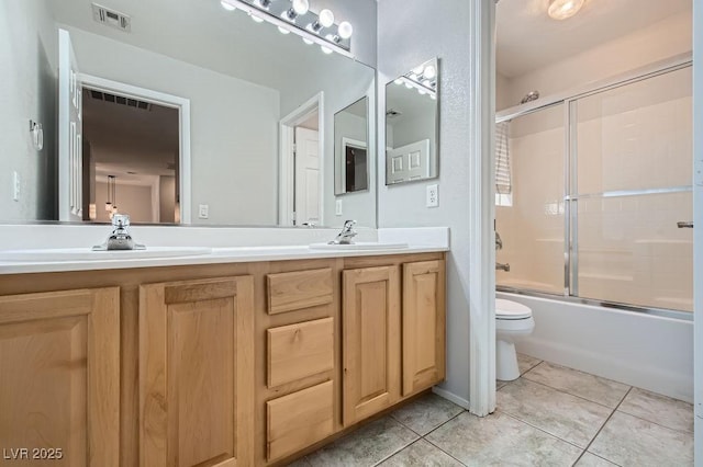 bathroom featuring double vanity, a sink, visible vents, and tile patterned floors