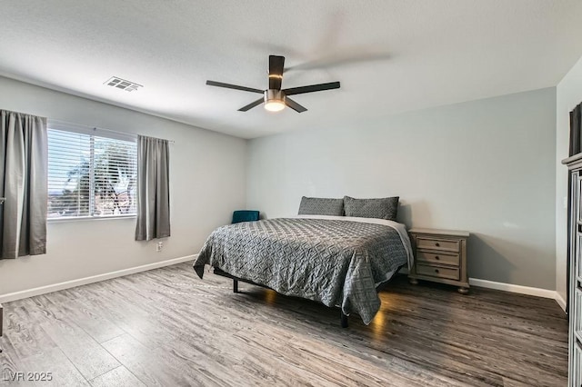 bedroom with a ceiling fan, baseboards, visible vents, and wood finished floors