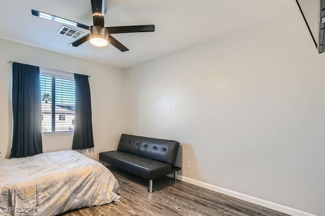 bedroom featuring a ceiling fan, wood finished floors, visible vents, and baseboards