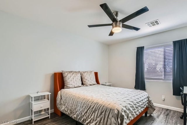 bedroom featuring a ceiling fan, visible vents, baseboards, and wood finished floors