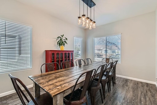 dining space with dark wood-style floors, baseboards, and a notable chandelier