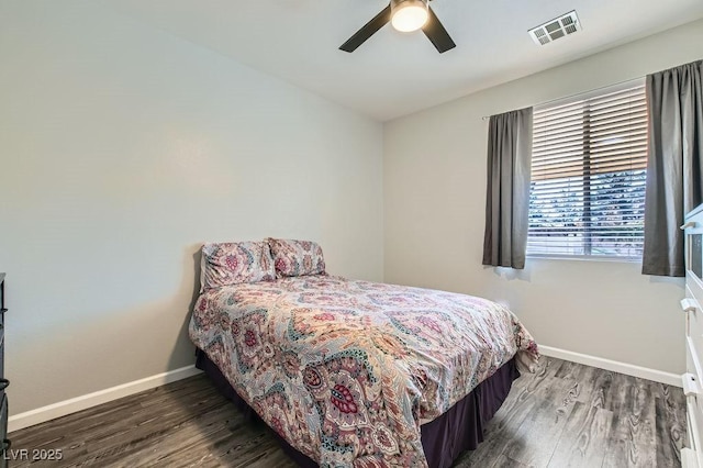 bedroom with a ceiling fan, wood finished floors, visible vents, and baseboards