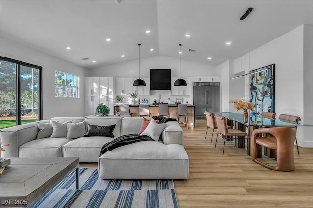 living area featuring visible vents, recessed lighting, high vaulted ceiling, and light wood-style floors