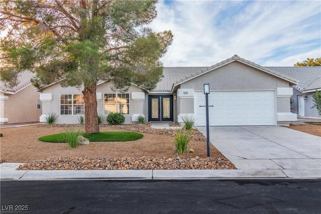 ranch-style home with stucco siding, driveway, french doors, an attached garage, and a tiled roof