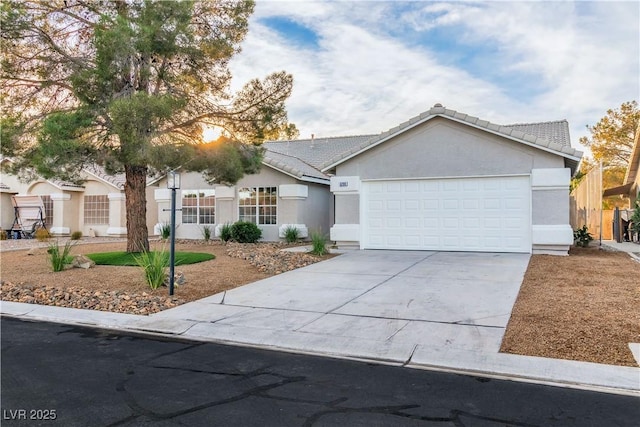 ranch-style home with fence, a tile roof, concrete driveway, stucco siding, and an attached garage