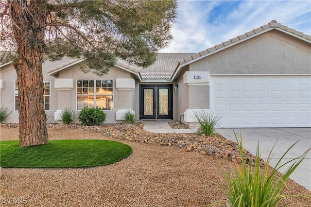 ranch-style house featuring an AC wall unit, a tile roof, concrete driveway, stucco siding, and french doors