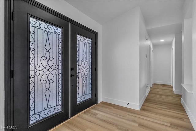 entryway with baseboards and light wood-style floors